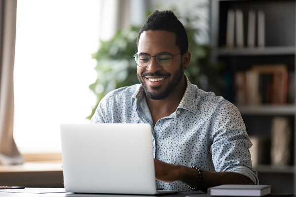 Smiling,Biracial,Man,In,Glasses,Sit,At,Desk,In,Office