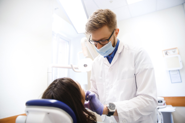Close-up process is removal of forceps by dentist in clinic. Concept health treatment, pain, phobia doctor.