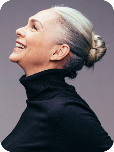 Side view of senior woman laughing on gray background.