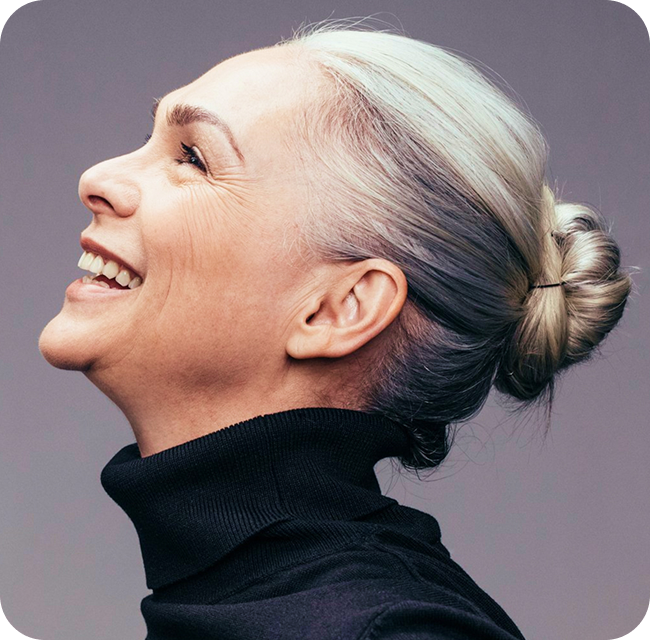 Side view of senior woman laughing on gray background