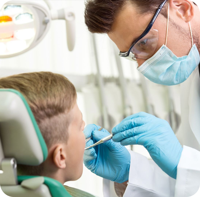 The doctor treats a tooth of little boy at dentist's clinic.